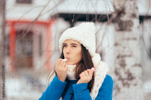 Happy Woman Applying Lip Balm Outdoors in Winter 