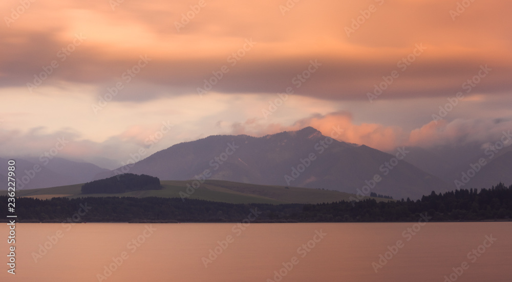 Long Exposure Shot of Liptovska Mara Lake, Low Tatras Mountains and Cloudy Sky at Sunset.