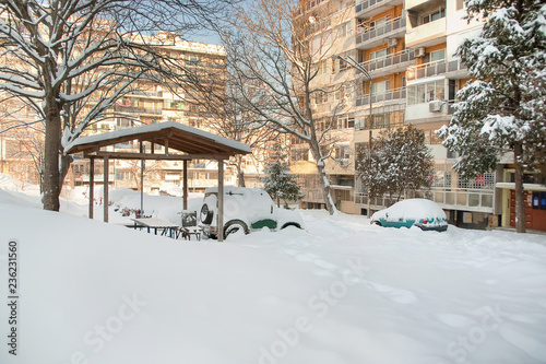 Piles of beautiful pure white snow over the wooden gazebo and the cars in the parking outdoor. Winter concept.