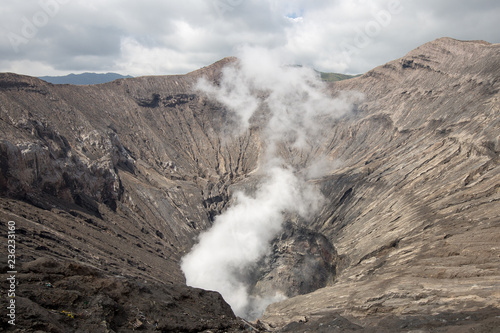 Active Volcano with smoke from crater of Mt Bromo, Indonesia, abstract and background on earth warning issue.