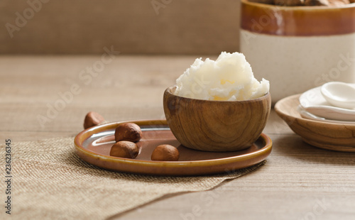 Fotografi Shea butter and nuts on a wooden board, copy space.