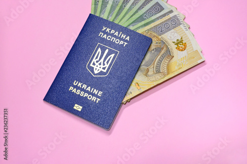 Fototapeta Ukraine passport with golden letters and trident emblem on pink blurred background with poland currency polish zloty