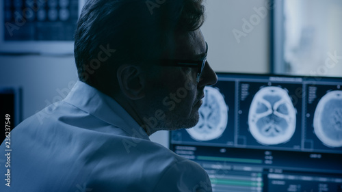 In Medical Laboratory Patient Undergoes MRI or CT Scan Process under Supervision of Radiologist in Control Room, He Watches Procedure and Monitors Brain Activity Results.