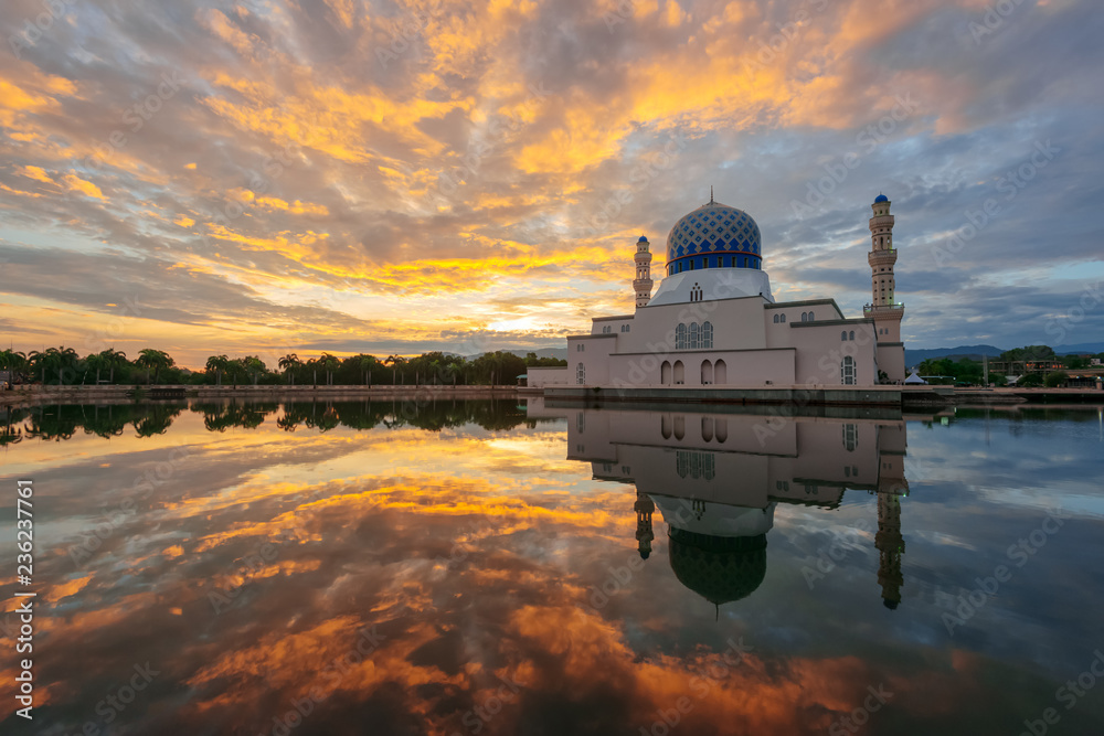 Dramatic fiery cloud on the sky and its reflection on the lake during sunrise captured at the beautiful floating mosque at Kota Kinabalu, Sabah, Malaysia.