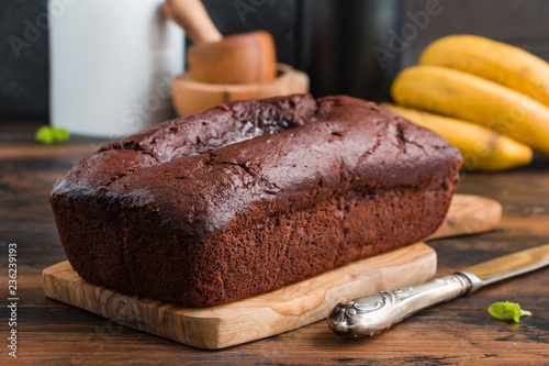 Chocolate banana bread and fresh fruits on wooden rustic table photo