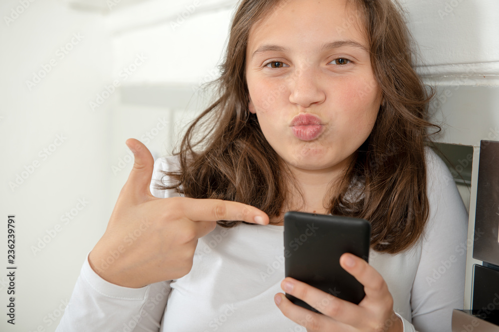 teenage girl using smartphone in the kitchen teenage girl using smartphone in the kitchen