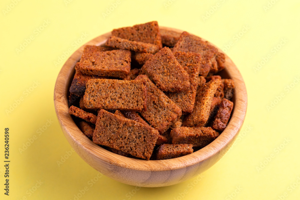 Rye salted crackers in wooden bowl on bright colored background