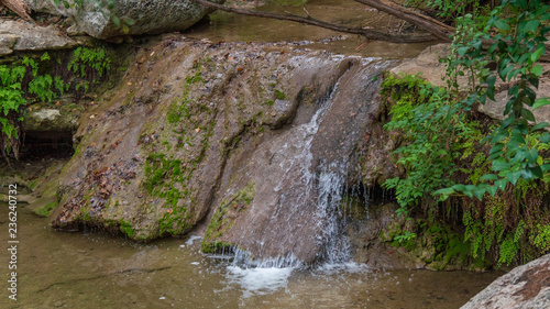 Small waterfall in river, during fall with colorful leaves