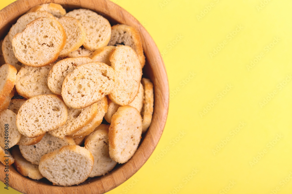 Wheat salted crackers in wooden bowl on bright colored background Wheat salted crackers in wooden bowl on bright colored background
