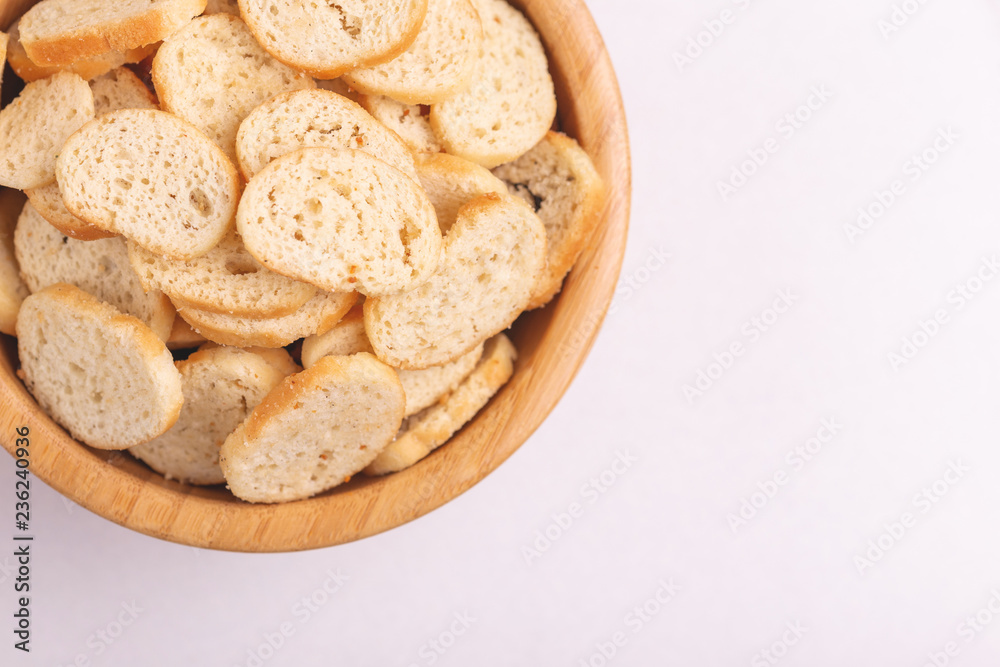 Wheat salted crackers in wooden bowl on light marble background