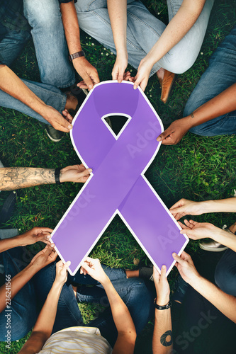Group of people holding a purple colored ribbon photo