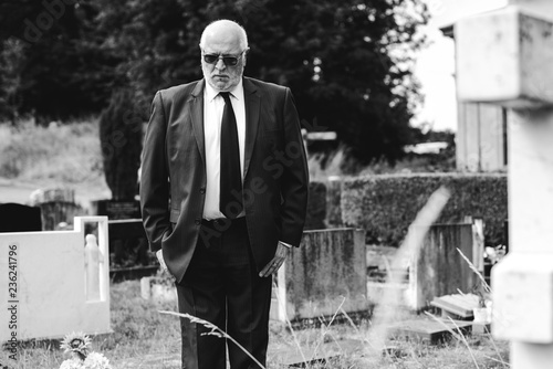 Lonely widower mourning at the graveyard