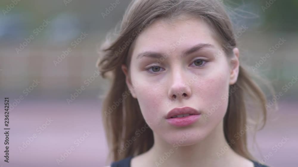 Portrait of a pretty girl straightens her hair outdoors Young girl with beautiful eyes and tender lips gently straightens hair and looks into the camera A young girl flirts with the camera Portrait of a pretty girl straightens her hair outdoors Young girl with beautiful eyes and tender lips gently straightens hair and looks into the camera A young girl flirts with the camera