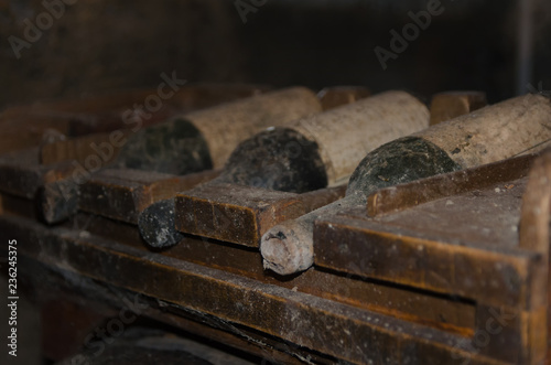 Very old wine bottles overed with dust and cobwebs in wine cellar .Aging Wine background with copy space.