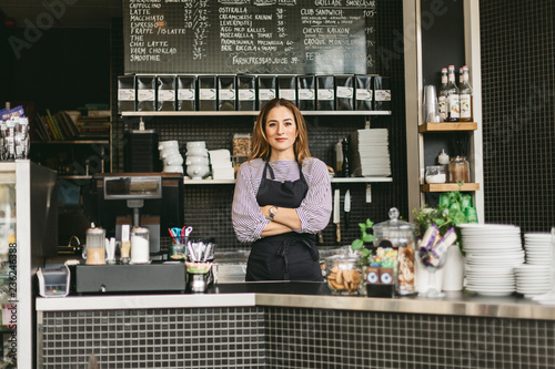 Portrait of barista behind counter in cafe photo