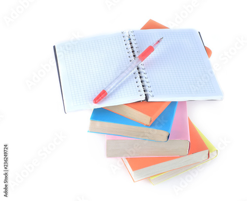 open the notebook, pen and a stack of books on white background