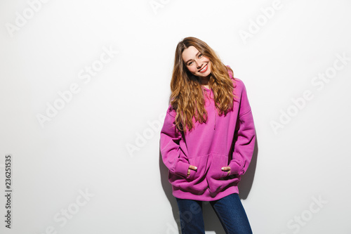 Image of pretty woman 20s wearing sweatshirt smiling, isolated over white background