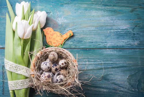 easter composition consists of a white tulips, quail eggs photo