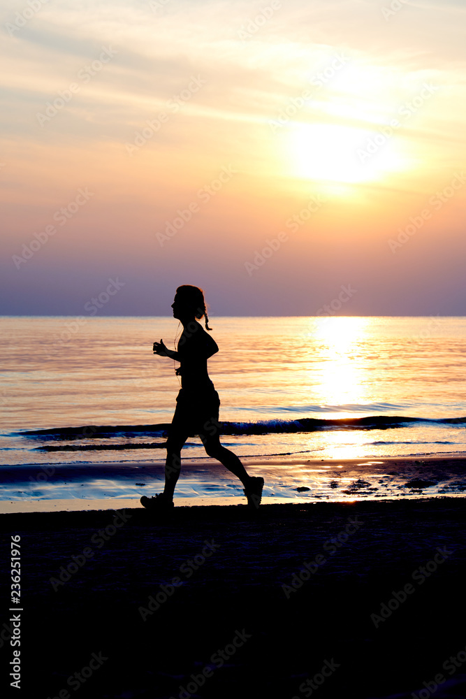 Photo of silhouette in the morning. Female athlete are jogging by the sea.