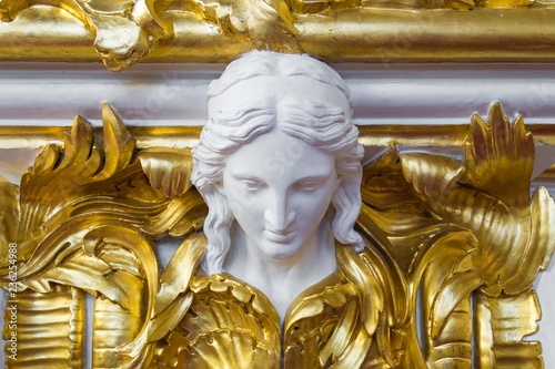 Woman head antique sculpture on gold wall