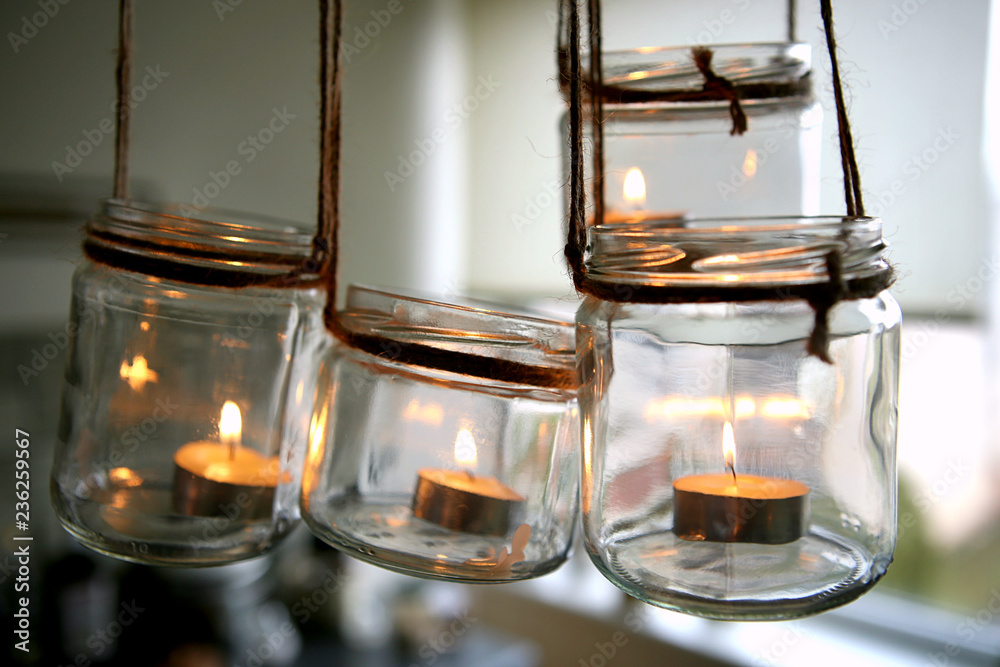 Aromatic candles in glass jars hanging in kitchen. DIY candles in glass jars hanging on linen jute. 