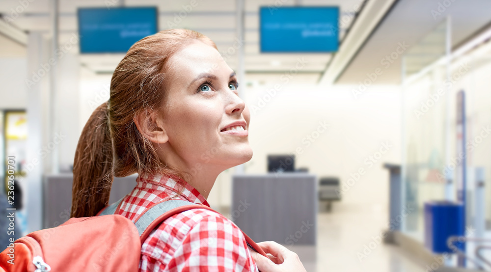 travel, tourism and people concept - smiling young woman with backpack over airport terminal background travel, tourism and people concept - smiling young woman with backpack over airport terminal background