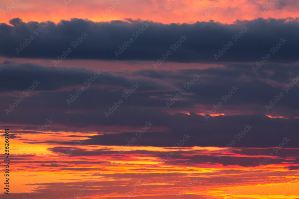 Beautiful dramatic sunset orange sky with blue violet clouds