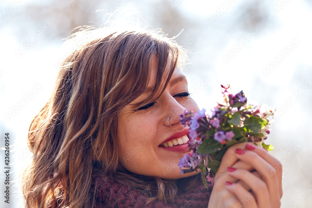 Cute young girl smelling nice bouquet of flowers in nature. Cute young girl smelling nice bouquet of flowers in nature.