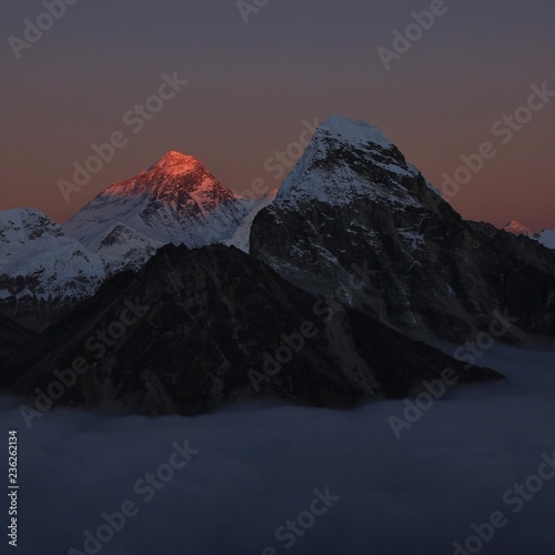 Last sunlight of the day illuminating the peak of Mount Everest. Sea of fog. View from a secret place in the Gokyo Valley, Nepal.