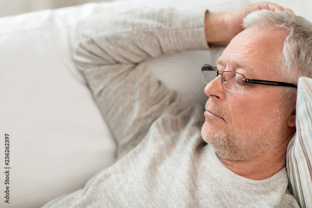 Obraz premium old age, rest, comfort and people concept - senior man sleeping on sofa at home