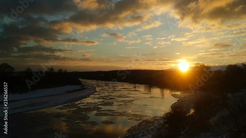 Stunning winter landscape with moving ice floes and clouds at sunset, timelapse footage