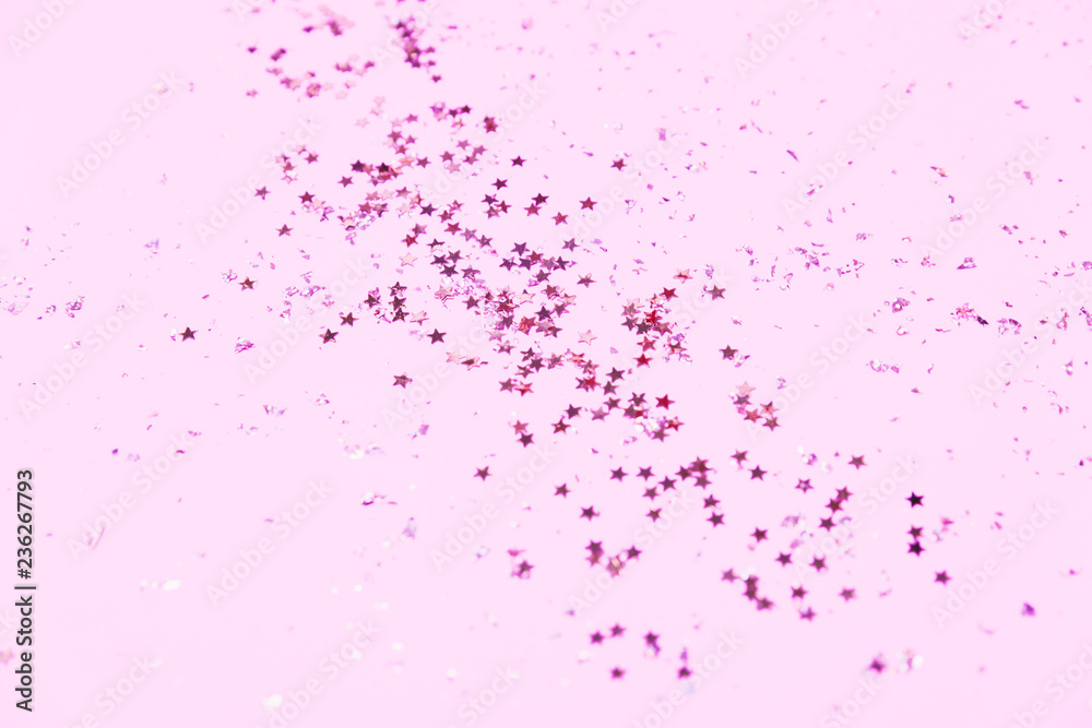 Pink confetti and stars and sparkles on pink background.