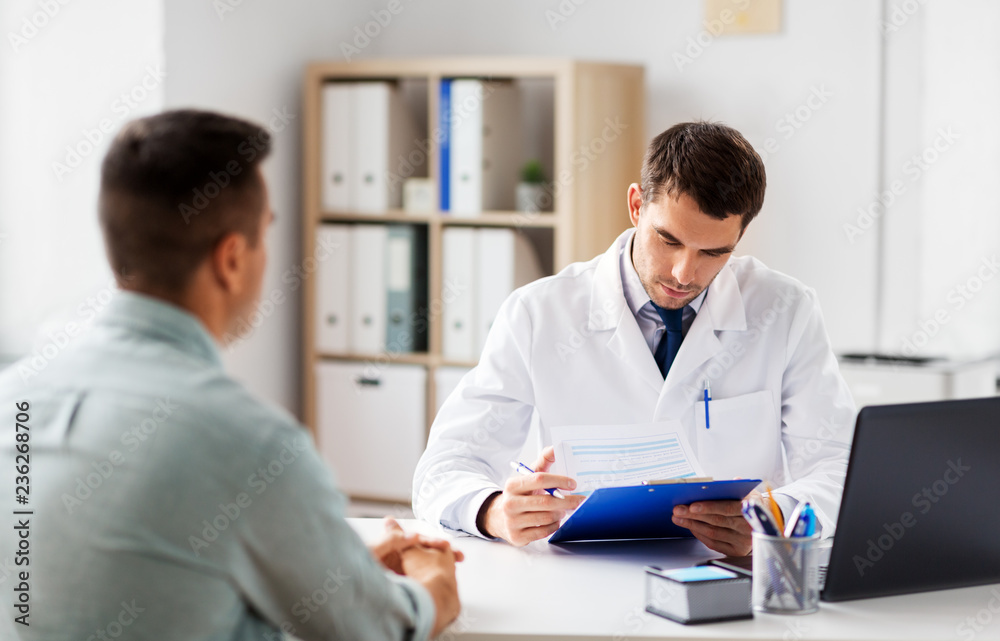 medicine, healthcare and people concept - doctor with clipboard and male patient at medical office in hospital