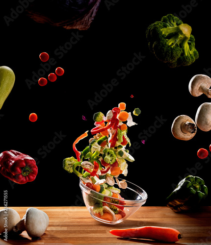 Bowl on board between vegetables in air photo