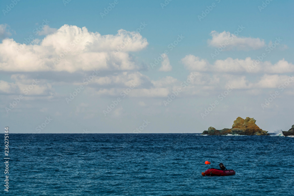 Amazing landscape of mountain with red boat on the sea with blue and cloudy sky. Red boat on the beach with blue sea and blue sky background. Amazing landscape of mountain with red boat on the sea with blue and cloudy sky. Red boat on the beach with blue sea and blue sky background.