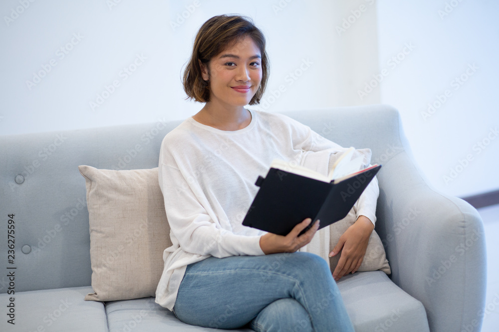 Smiling successful manager preparing for Monday presentation at weekend. Beautiful young woman studying her notebook at home. Working at home concept Smiling successful manager preparing for Monday presentation at weekend. Beautiful young woman studying her notebook at home. Working at home concept