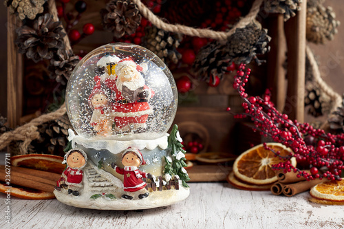 Obraz na płótnie Musical Snow Globe with Santa Claus on wooden background w salonie
