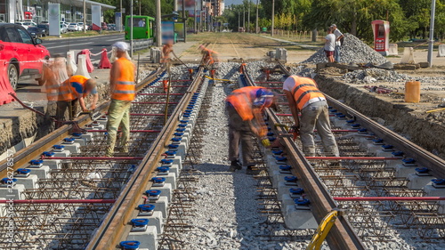 Repair works on the street timelapse. Laying of new tram rails on a city street photo