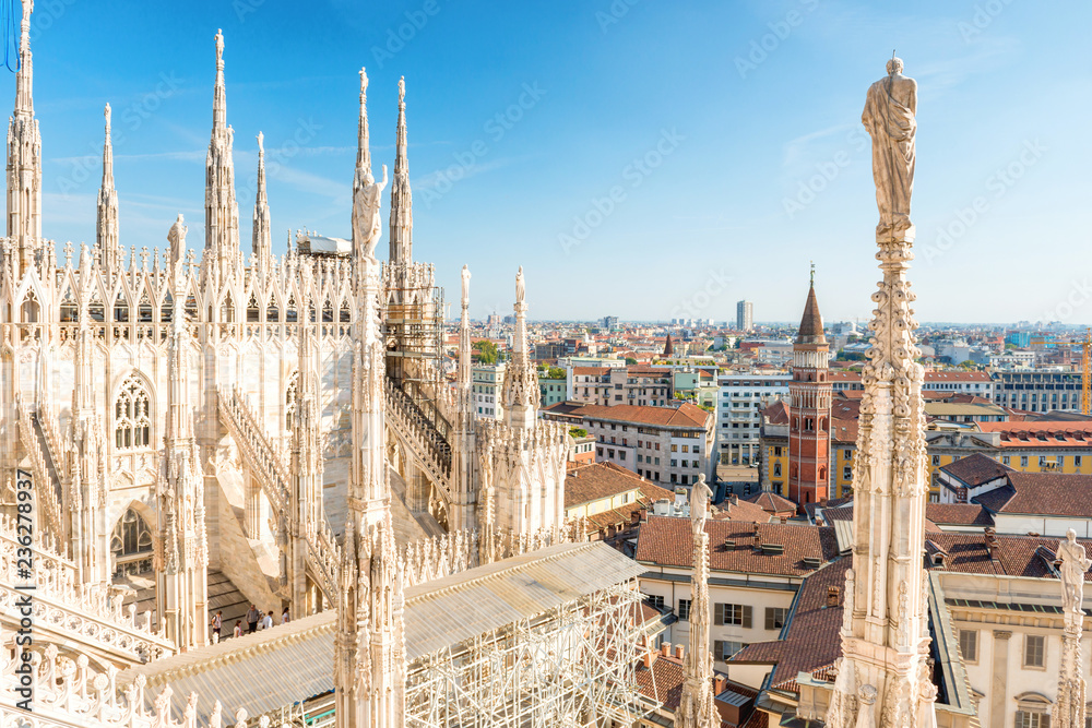 Fototapeta premium Biały posąg na szczycie katedry Duomo i widok na Mediolan