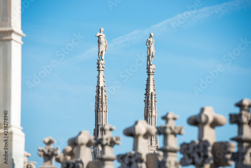 Marble statues - architecture on top of roof Duomo gothic cathedral in Milan, Italy