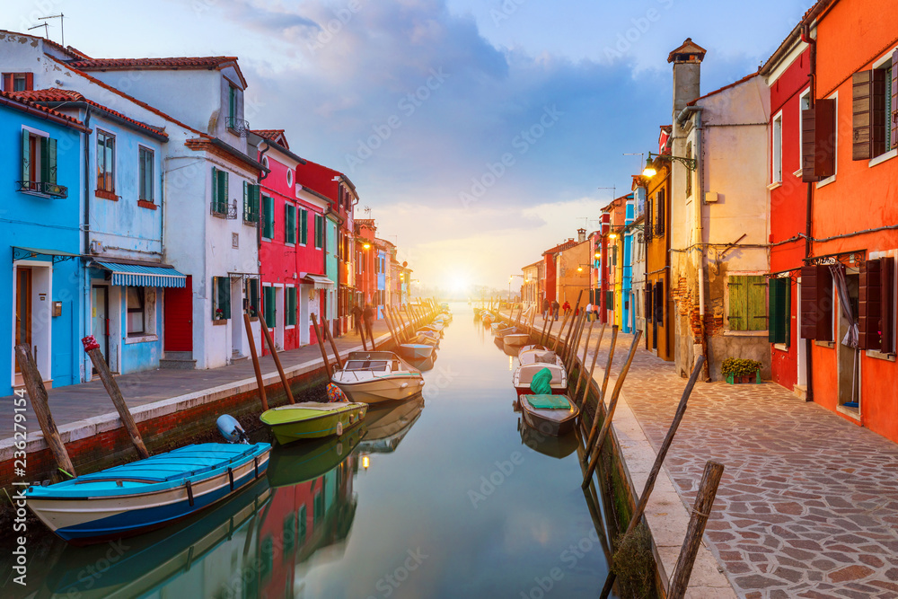 Beautiful view of the canals of Burano with boats and beautiful, colorful buildings. Burano village is famous for its colorful houses. Venice, Italy.