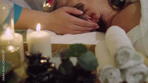 Crane shot. Young chinese doctor doing cosmetic massage of a neck to a senior woman