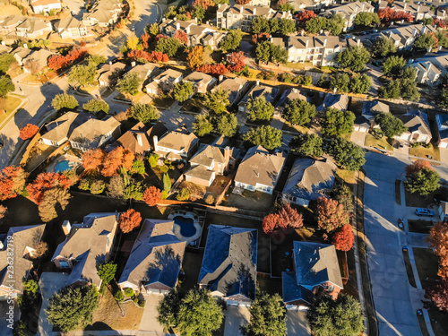 Aerial view planned unit development with apartment building complex and residential house surrounded by colorful fall foliage. Flyover community area suburban Dallas, Texas, USA