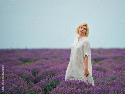 Fototapeta Naklejka Na Ścianę i Meble -  Young girl in white dress, posing in a lavender field.