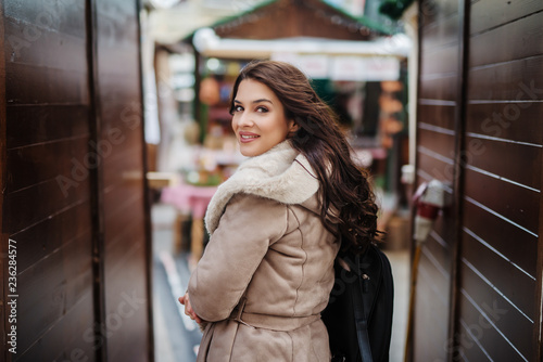 Beautiful Caucasian woman dressed in coat looking over the shoulder. © dusanpetkovic1