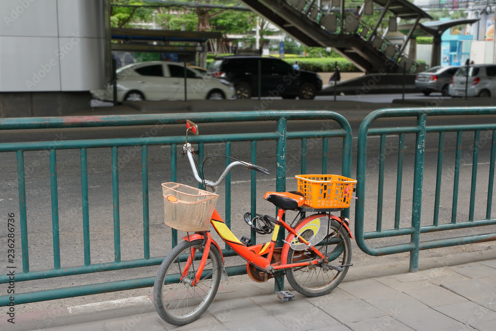 closeup of a bicycle parking on pavement and locked to street barrier
