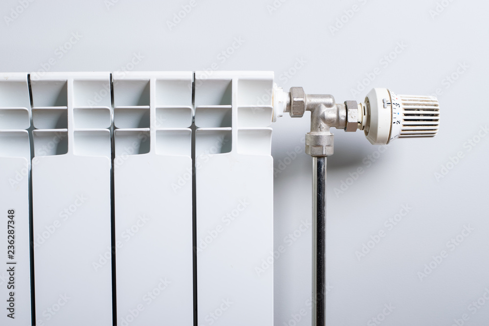 A White heating radiator on the wall. A White heating radiator on the wall.