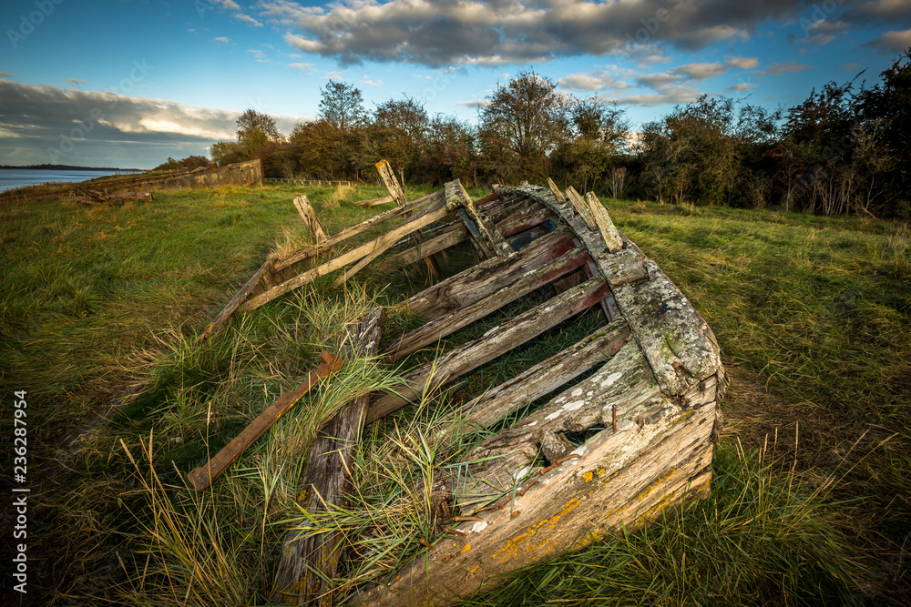 Obsolete small boats and barges were beached on the banks of the tidal River Severn in Gloucestershire, UK to protect the river banks from erosion
