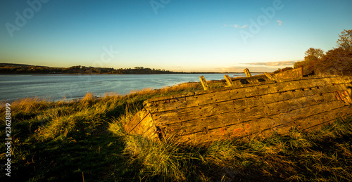Fototapeta Naklejka Na Ścianę i Meble -  Obsolete small boats and barges were beached on the banks of the tidal River Severn in Gloucestershire, UK to protect the river banks from erosion