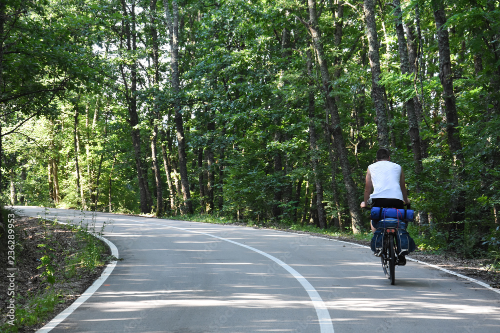 Cyclist with a saddle bag on the road. Traveler on bicycle on long way